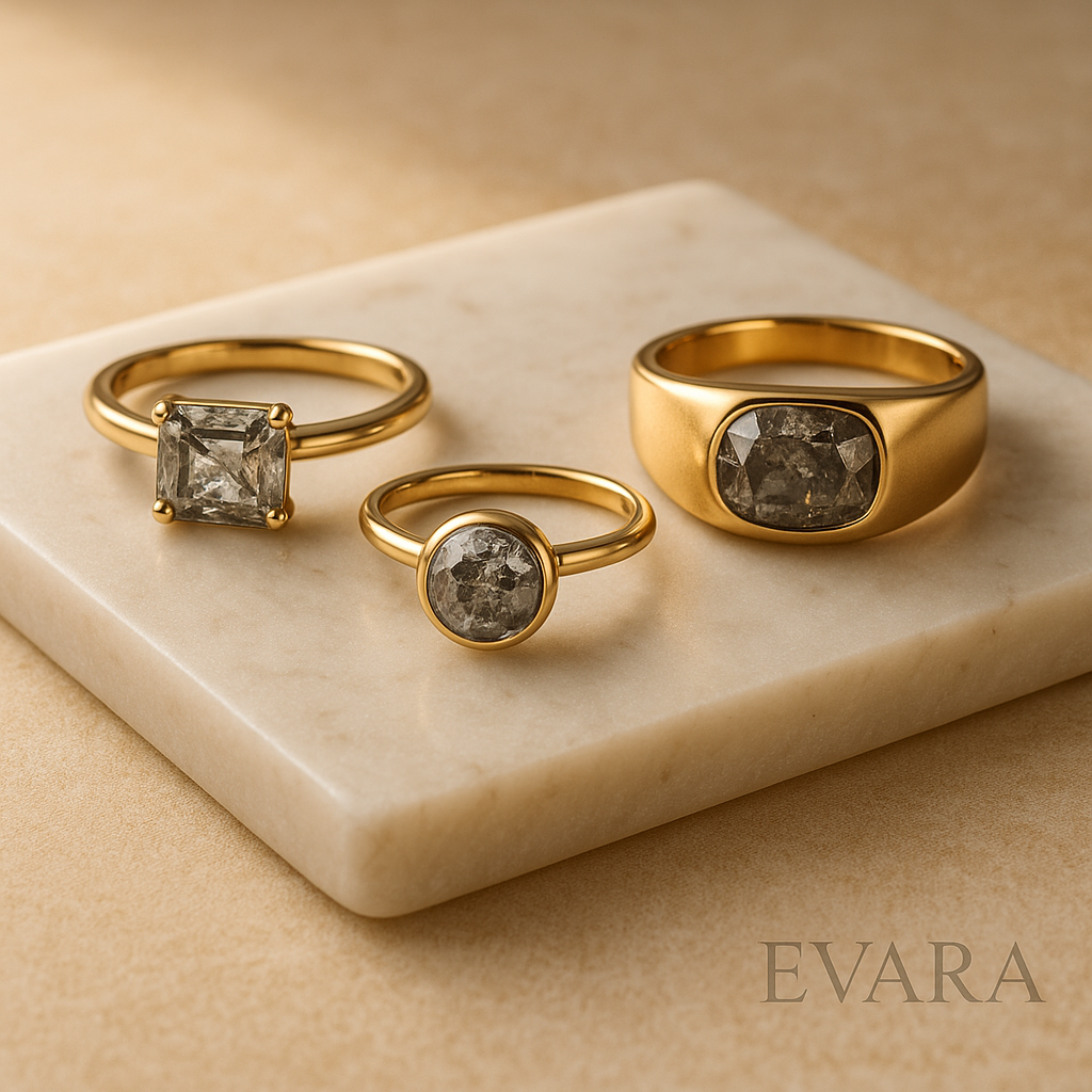 Editorial display of salt and pepper diamond rings in east-west emerald, bezel, and bold gold band styles.